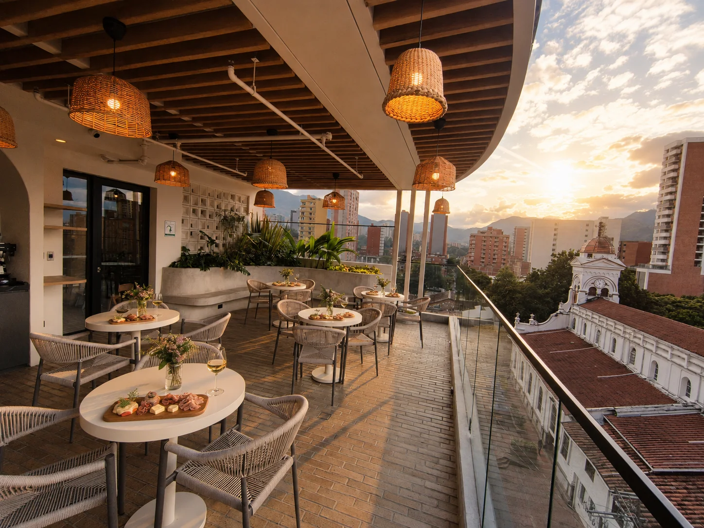 Vista de la terraza de Tres Altares al atardecer, con mesas y vista a la ciudad
